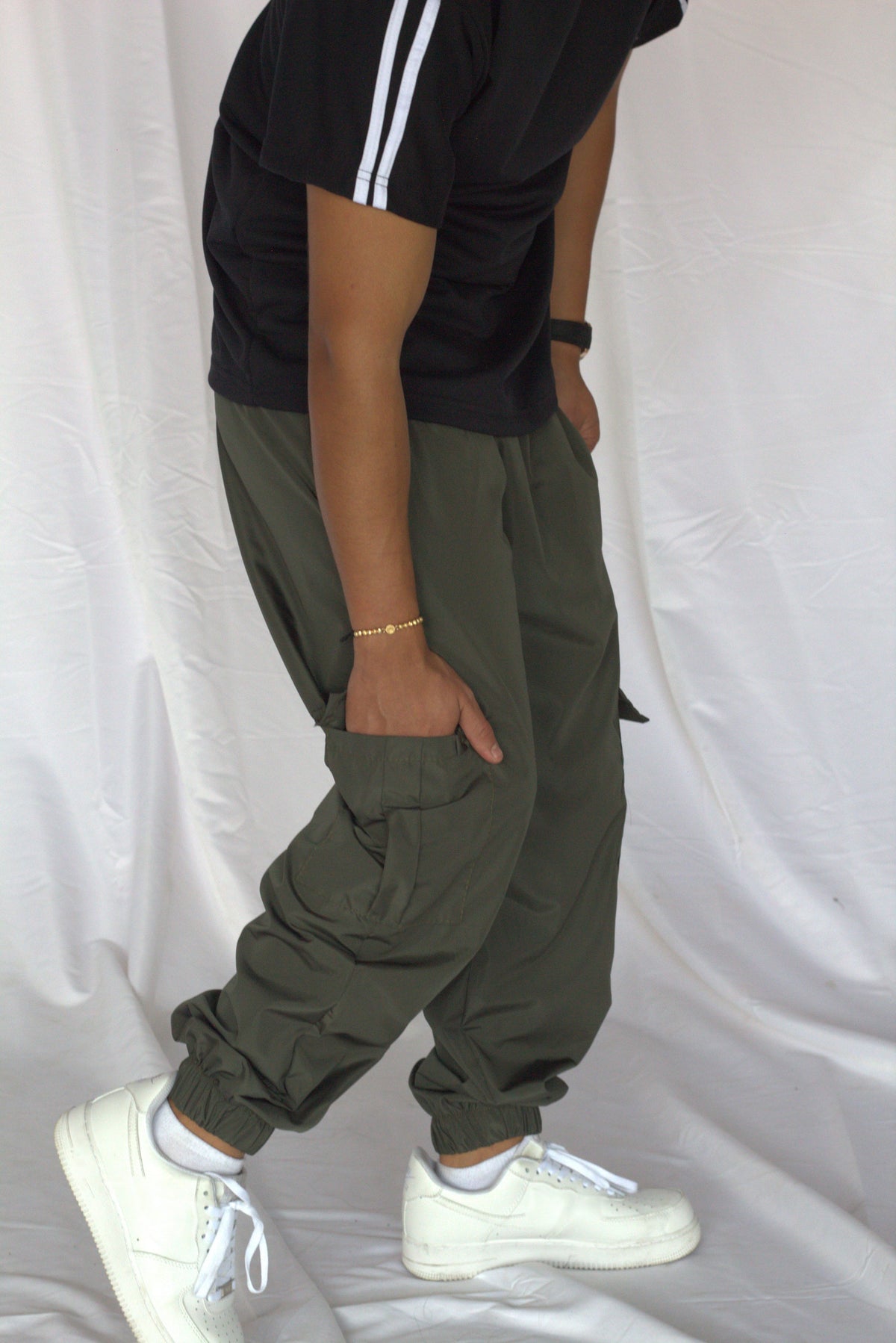 Jogger cargo verde militar vista lateral con cintura elástica y bota resortada sobre tenis